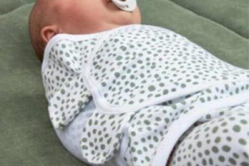 Ingebakerde baby volverwachting Vol Verwachting - Baby die is ingebakerd in een wit met groen gestipte wikkeldoek