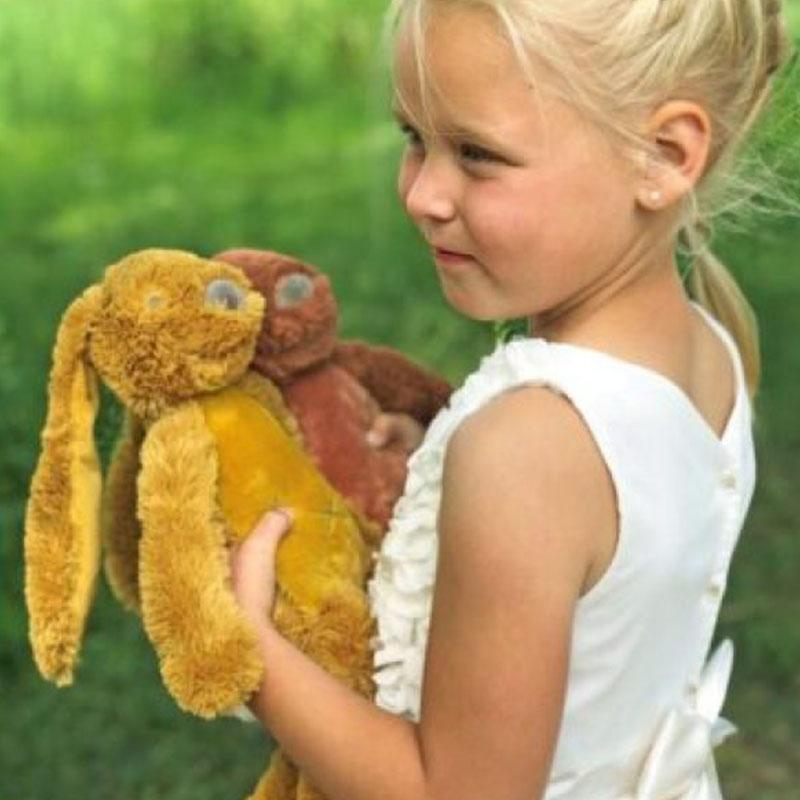 kind met knuffels vol verwachting Vol Verwachting - Meisje met twee verschillende knuffel konijnen buiten